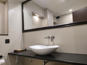 a bathroom with a white sink and a mirror at Hotel Elite International in Trichūr