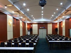 a conference room with rows of chairs and a projector at Hedong Hotel in Shenzhen