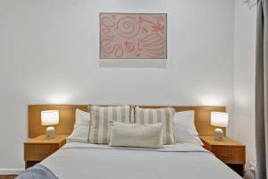 ein Schlafzimmer mit einem Bett und zwei Lampen an beiden Seiten in der Unterkunft Shell Escape in Broome + 23 Fotos