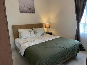 a bedroom with a bed with a green comforter at Homestay by Hiraya in San Pedro