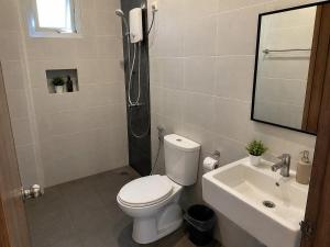 a bathroom with a toilet and a sink at Homestay by Hiraya in San Pedro