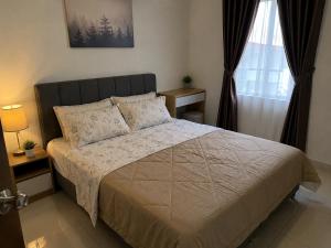 a bedroom with a large bed and a window at Homestay by Hiraya in San Pedro