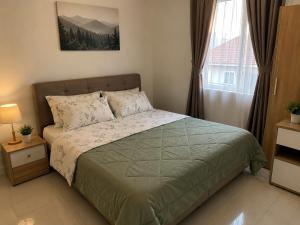 a bedroom with a bed and a large window at Homestay by Hiraya in San Pedro