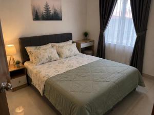 a bedroom with a bed and a window at Homestay by Hiraya in San Pedro