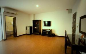 a living room with a wooden floor and a television at Maytara Hotel in Pattaya South