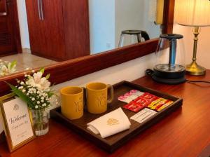 a table with two cups and a tray of food at Bravon Sky Hotel in Kurunegala