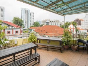 a balcony with benches and a view of a city at G4 Station Backpackers Hostel in Singapore