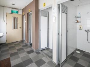 a bathroom with a row of doors and a sink at G4 Station Backpackers Hostel in Singapore +192 photos