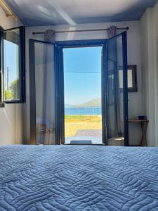a bedroom with a bed and a view of the ocean at Maria's Seafront Villa in Loutra Edipsou
