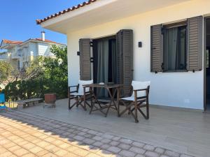 a patio with chairs and a table on a house at Maria's Seafront Villa in Loutra Edipsou +11 photos