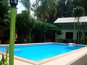 a blue swimming pool with a green pole next to a house at Nayai Resort in Chalong +26 photos