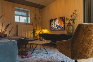 a living room with a couch and a table at Stijlvol 4-6 pers "Vakantiehuis De Meierij" - compleet ingericht huis met vrij weidezicht in Schijndel