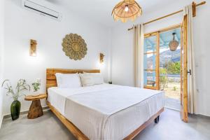 a bedroom with a large white bed and a window at Amaranthos Garden Retreat in Skopelos Town