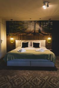 a bedroom with a large bed with two towels on it at Stijlvol 4-6 pers "Vakantiehuis De Meierij" - compleet ingericht huis met vrij weidezicht in Schijndel