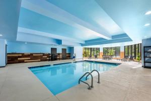 a large swimming pool with blue ceilings and windows at Comfort Suites New Bern near Cherry Point in New Bern