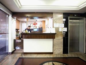 a man standing at the counter of a restaurant at Darlene Hotel in Singapore