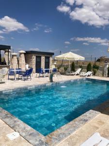 a swimming pool with chairs and a table and chairs at İncebey Konak Cappadocia Swimming Pool in Uçhisar