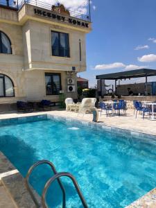 a pool at a hotel with chairs and tables at İncebey Konak Cappadocia Swimming Pool in Uçhisar