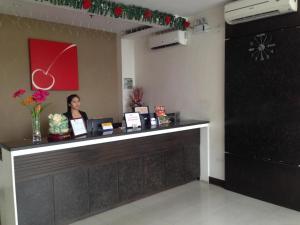 a woman standing at a counter in a room at Cherry Midtown Hotel in Bahac-bahac