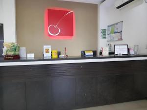 a counter in a store with a red clock on the wall at Cherry Midtown Hotel in Bahac-bahac