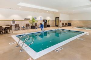 a pool in a hotel room with a woman standing next to it at Comfort Suites Midland West in Midland