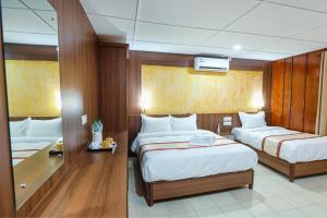 a hotel room with two beds and a mirror at Batika Resort Sauraha in Sauraha