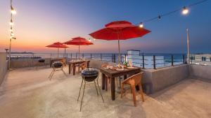 a patio with tables and umbrellas on a roof at Gangneung Glad Pension in Gangneung