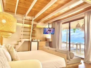 a living room with a bed and a couch and a tv at Tonsak Resort in Ko Samed