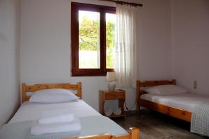 two beds in a room with a window at Theros Beach House in Stavros