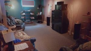 a living room with a couch and a tv at Au Soleil Couchant in Val-dʼOr
