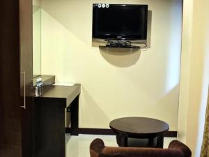 a room with a table and a tv on a wall at Peridot Suites in Buhangin +214 photos