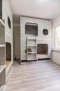 a room with a wall with shelves and a window at Arch Hostel in Almaty