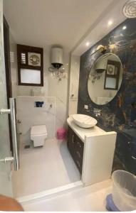 a bathroom with a sink and a toilet and a mirror at Hotel elora 