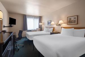 a hotel room with two beds and a television at Travelodge by Wyndham Drummondville in Drummondville