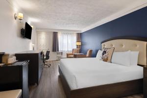 a bedroom with a large bed and a blue wall at Travelodge by Wyndham Drummondville in Drummondville