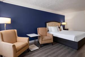a hotel room with a bed and two chairs at Travelodge by Wyndham Drummondville in Drummondville +88 photos