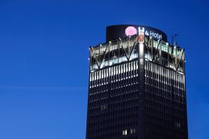 a building with a clock on the top of it at H4 Wyndham Paris Pleyel in Saint-Denis