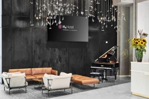 a living room with a couch and a piano at H4 Wyndham Paris Pleyel in Saint-Denis +185 photos