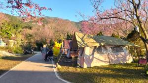 a group of people walking down a road with a tent at กลางขุนเขา klang khun khao in Ban Na Yang