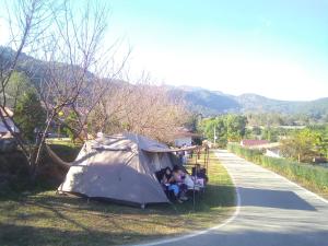a group of people sitting in a tent on the side of a road at กลางขุนเขา klang khun khao in Ban Na Yang