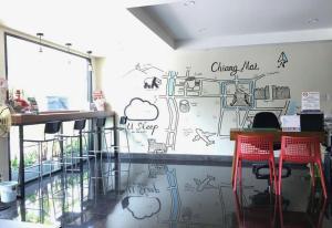 a restaurant with a wall with drawings on it at U Sleep Chiangmai in Chiang Mai