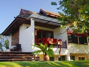 a house with a red chair in front of it at Doltara Boutique Resort in Chiang Mai