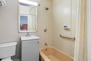 a bathroom with a tub and a sink and a mirror at Rodeway Inn in Somerset +53 photos