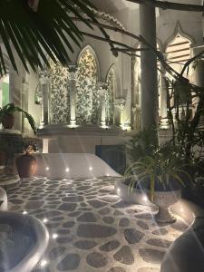 a bathroom with a tub and plants on a tiled floor at La Casa del Sol in Kandy