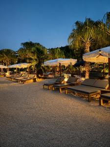 a row of picnic tables and umbrellas on a beach at Korcula Holiday in Korčula