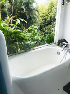 a bath tub in a bathroom with a window at La Casa del Sol in Kandy