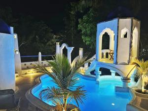 a resort with a blue swimming pool at night at La Casa del Sol in Kandy