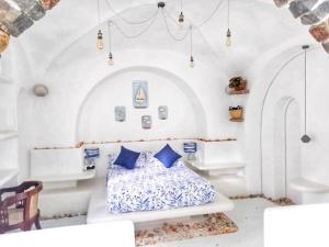 a white bedroom with a bed with blue pillows at La Casa del Sol in Kandy