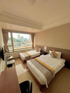 a hotel room with two beds and a large window at Grand Harbour Hotel in Macau