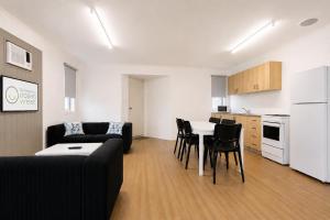 a living room with a couch and a table and a kitchen at Geraldton's Ocean West Holiday Units & Short Stay Accommodation in Geraldton